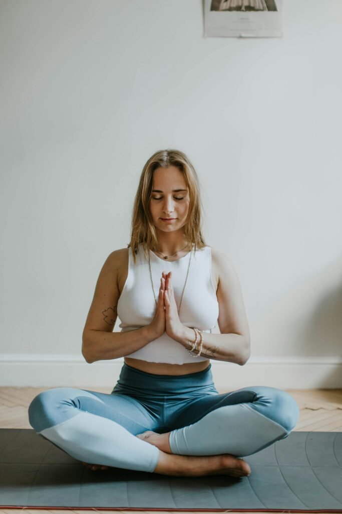 A serene image of a woman practicing meditation indoors, promoting mindfulness and wellbeing.